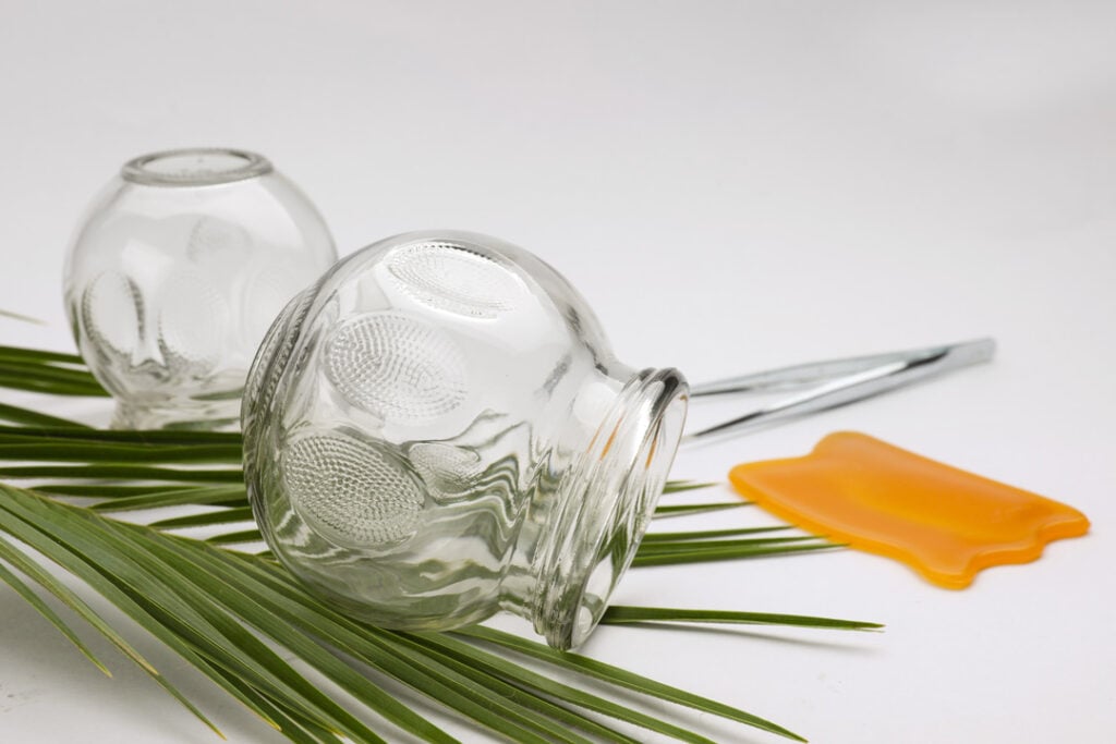 Glass cups, tweezers, gua sha and leaf