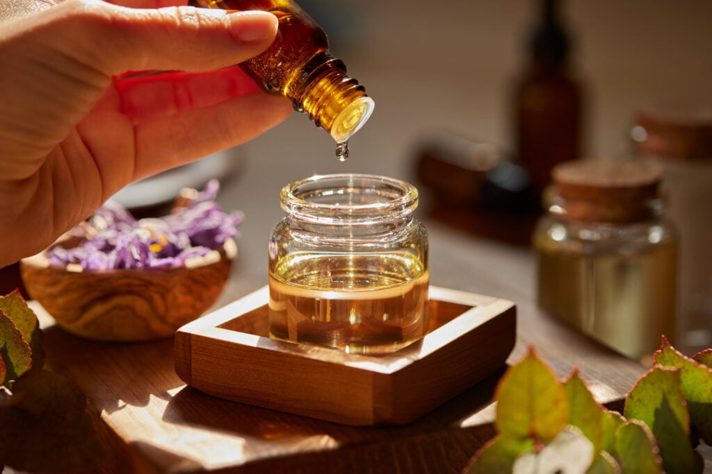 Preparing massage oil dropping essential oil
