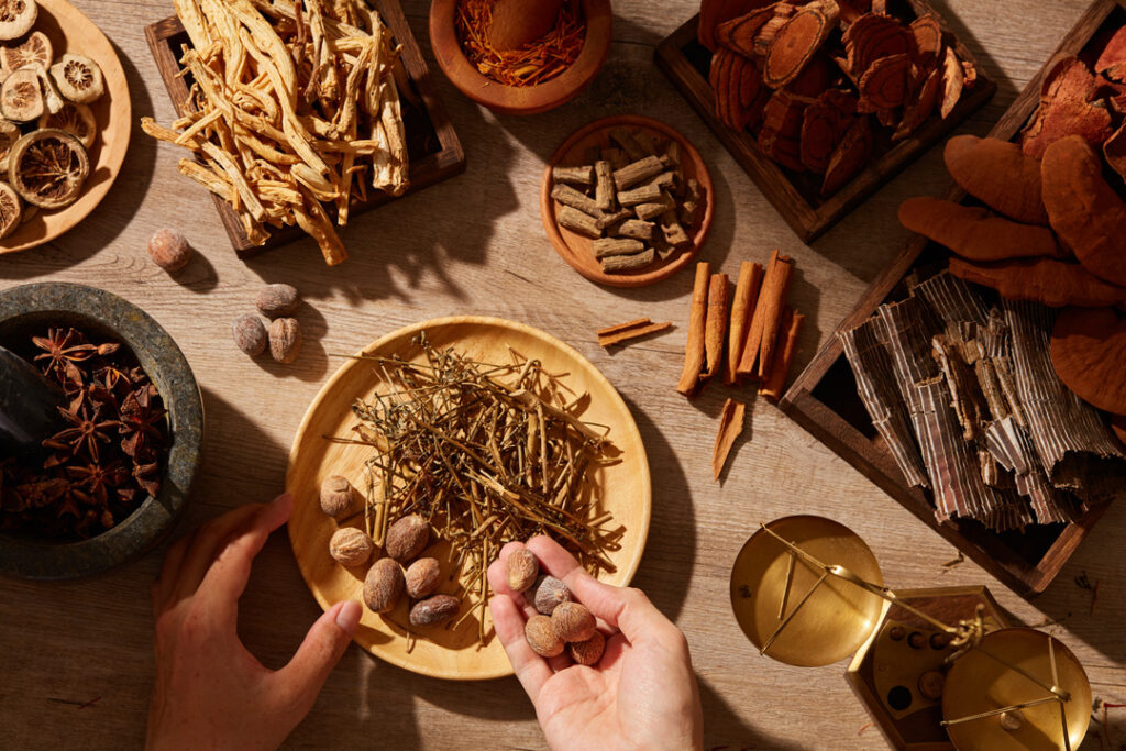 Traditional chinese medicine with herb and spices in brown wooden background mortar and pestile